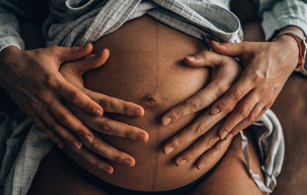Dad holding pregnant belly.
