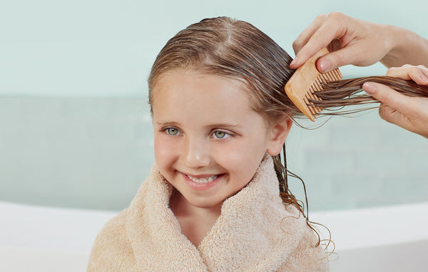 Girl getting her hair brushed after a bath. 