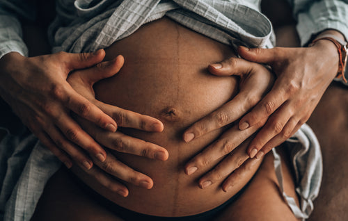 Dad holding pregnant belly.