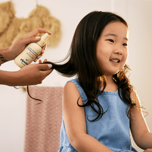 Applying Kids Detangler to Girl