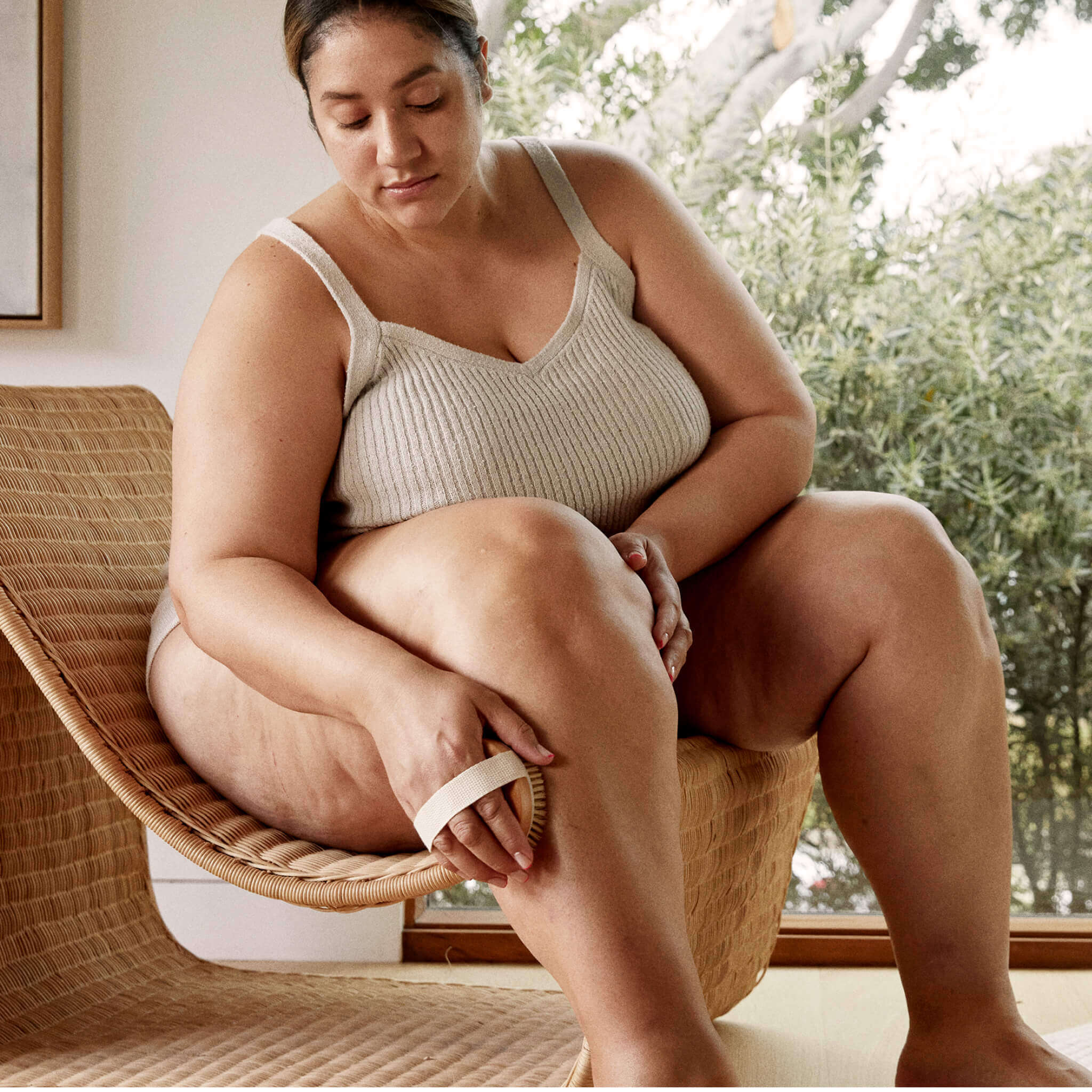 woman brushing and exfoliating her leg with a brush