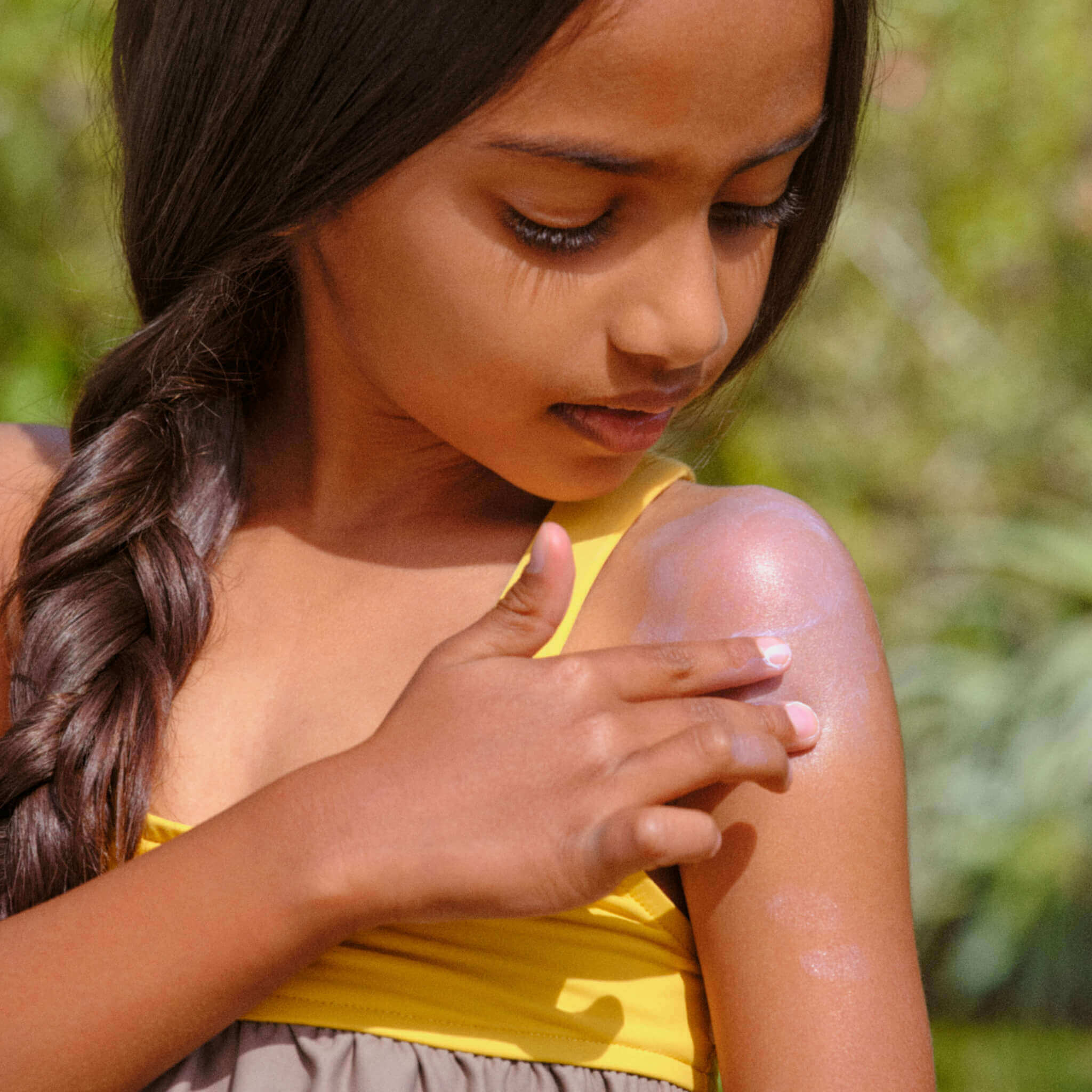 girl applying mineral sunscreen on her skin